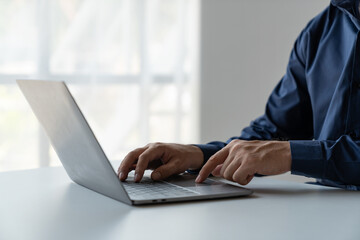 businessman working in a private room He is typing on a laptop keyboard. He uses a messenger to chat with colleagues in an online business. concept of using technology in communication.