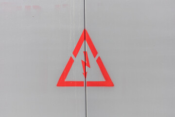 Sign (symbol) of the danger of high voltage electricity (triangle with lightning) on a metal...