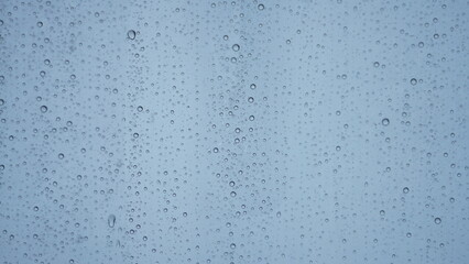 The rain droplets on the transparent glass window in the rainy day