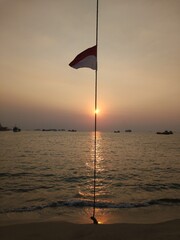 Silhouette of the flag of Indonesia on the beach of Merak at sunset