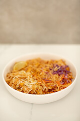 Close Up Photo of White Ceramic Bowl of Tofu Pad Thai with Lime Slice on Kitchen Counter Top