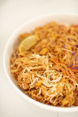 Close Up Photo of White Ceramic Bowl of Tofu Pad Thai with Lime Slice on Kitchen Counter Top