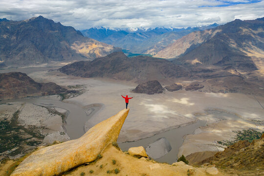 A tourist man climbing Marsur Rock cliff in Karakoram high mountain hills. Nature landscape background, Skardu-Gilgit, Pakistan. Travel on holiday vacation. People lifestyle
