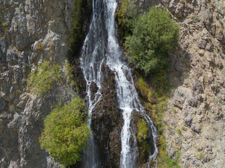 Obraz premium Aerial top view of Mantoka Waterfall in Karakoram high mountain hills. Nature landscape background, Skardu-Gilgit, Pakistan. Travel on holiday vacation.