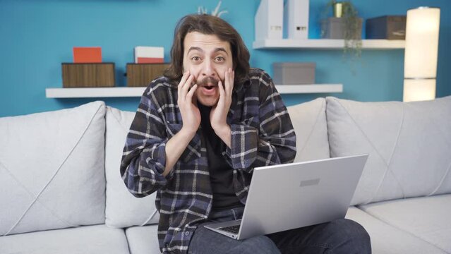 Man looking at laptop is surprised and happy.
The man using the computer is surprised and rejoicing at what happened. Very happy.
