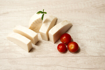 Majorero cheese on the kitchen table with cherry tomatoes. Made with goat's milk, Majorera, Fuerteventura Island. Spain