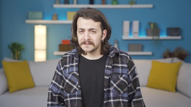 Man looking at camera with negative and sad facial expression. Gestures.
Man looking at camera with negative expression, shaking his head and upset.
