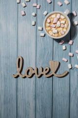 Wooden word love with heart romance with white coffee cup of hot chocolate and small marshmallows. Minimal concept of greeting card for Valentine's Day, Mother's Day, Women's Day Festive holiday card