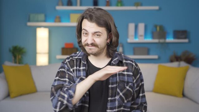 Man looking at camera making negative sign.
The man looking at the camera gives a negative sign because he doesn't like it.
