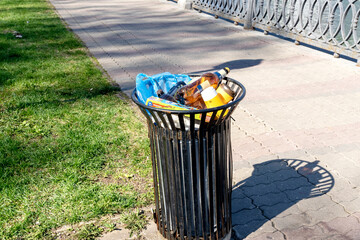trash bin full of trash in the park