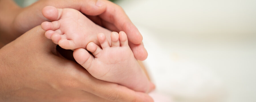 Asian Baby feet in mother's hands that mean symblo of love. Mom and her Baby Child. Happy Family concept. Beautiful conceptual image of Mother and newborn baby family