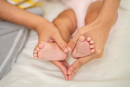 Asian Mother hands in heart shape. Baby feet in mother's hands that mean symblo of love. Mom and her Baby Child. Happy Family concept. Beautiful conceptual image of Mother and newborn baby family