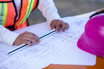 A pair of hands working on an architectural plan with a scaler
