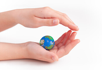 small globe in children's hands on a white background