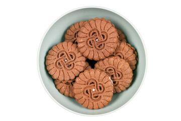 Round biscuits with filling in a plate on a white background. Brown cookies. Confectionery on a white background.