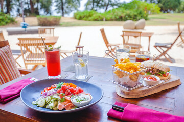 Table with delicious colorful food in outdoor beach hotel restaurant. Exotic summer vacation. Tropical beach lifestyle. Travel concept.