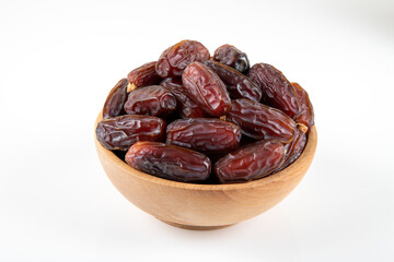 Date fruits in wooden bowl,on white background,top view
