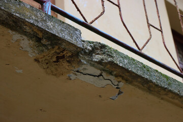 Damaged balcony on a old house in Italy. Balcony with cracked concrete. Balcony repair, cracks in...