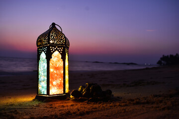 A beautiful background for Ramadan and Eid Al Fitr on a sea side, Lantern lamp with light in a colourful sky selective focus