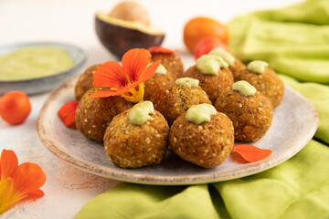 Falafel with guacamole on white concrete. Side view, selective focus.