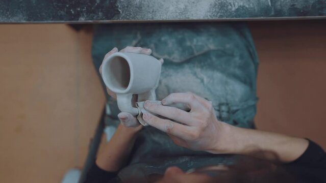 The process of working with clay, a clay master class, making a mug out of clay