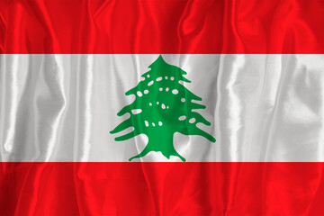 The lebanon flag on a silk background is a great national symbol. Texture of fabrics The official state symbol of the country