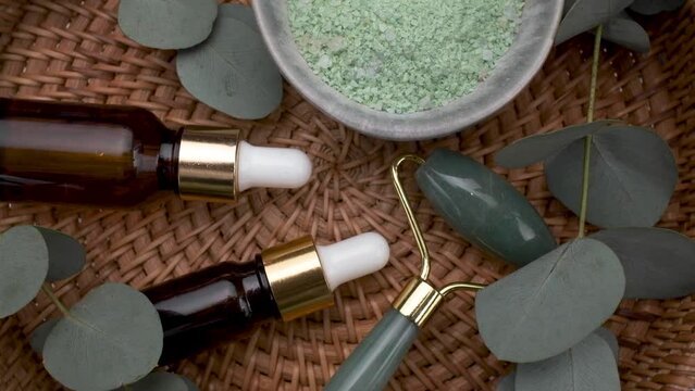 Natural, organic spa cosmetics products with eucalyptus oil, massage jade roller, eucalyptus leaf.