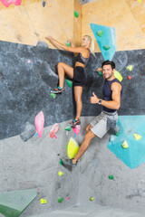 Couple of Caucasian Athletes Climbing Up Together on Steep Rock climbing on artificial wall indoors As Extreme sports and bouldering concept.