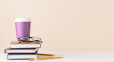 Coffee cup on stack of notepads