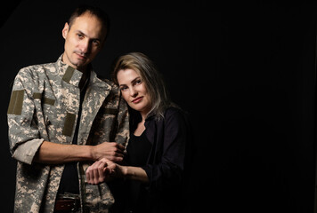 Fototapeta na wymiar military man and his wife on a black background