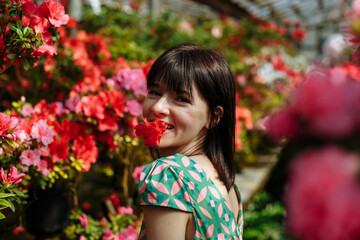 Naklejka premium A girl in a green dress with azaleas