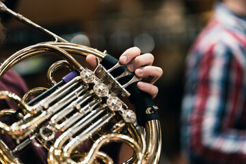 Fototapeta premium A French horn player playing their instrument during a wind ensemble rehearsal