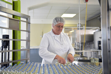 medical products manufacturing in a modern factory - glass bottles with medications on conveyor belt