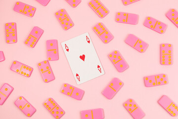 Poker playing card surrounded by pink domino on pink background