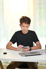 Fototapeta na wymiar Portrait of young man creative web designers using mobile phone at modern workplace