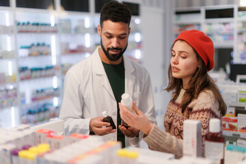 Young pharmacist helping customer to choos medication.