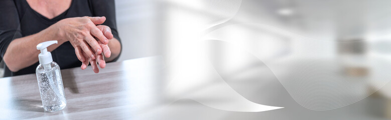 Woman rubbing her hands with sanitizer; prevention of virus and bacteria infection; panoramic banner
