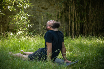 Caucasian man doing yoga in his garden