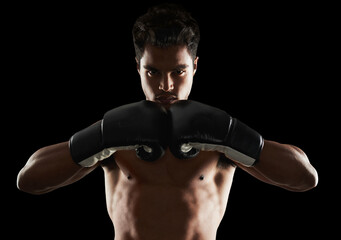 Hes dedicated to the sport of boxing. Portrait of a young male boxer in a fighting stance.