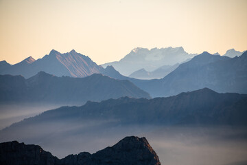 Fototapeta na wymiar Cold bluish mountain landscape in fog at sunrise