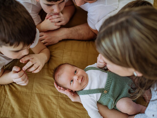 Big family with four kids enjoying their newborn baby.