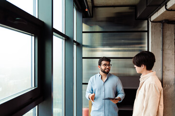 Two colleagues discussing project during meeting in office