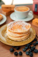 Delicious breakfast pancakes and coffee in wooden table with plants and decoration