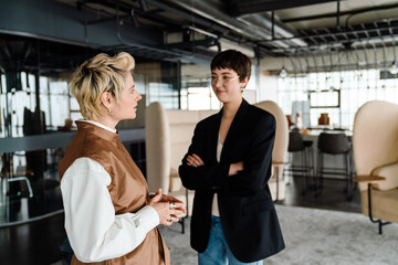 Two business women discussing project during meeting in office