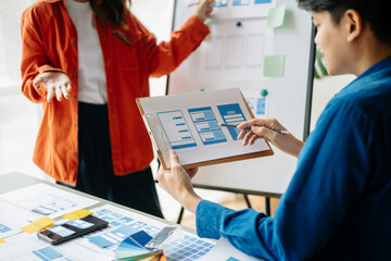  UX developer and ui designer brainstorming about mobile app interface wireframe design with...