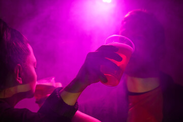 Obraz na płótnie Canvas Woman and man drinking beer in a nightclub.