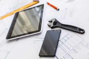 Construction blueprints with tools and tablet, top view