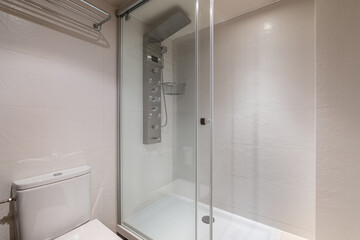 Glassed-in shower with modern controls next to the toilet in a compact bathroom. Concept of a bathroom in a five-star hotel or in new apartment. Copyspace