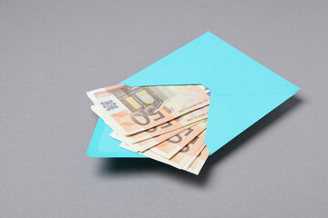 Envelope with Euro bills on gray background