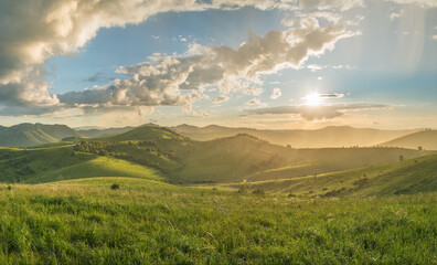 Evening rural landscape, the setting sun, sunset, spring nature, meadows and hills